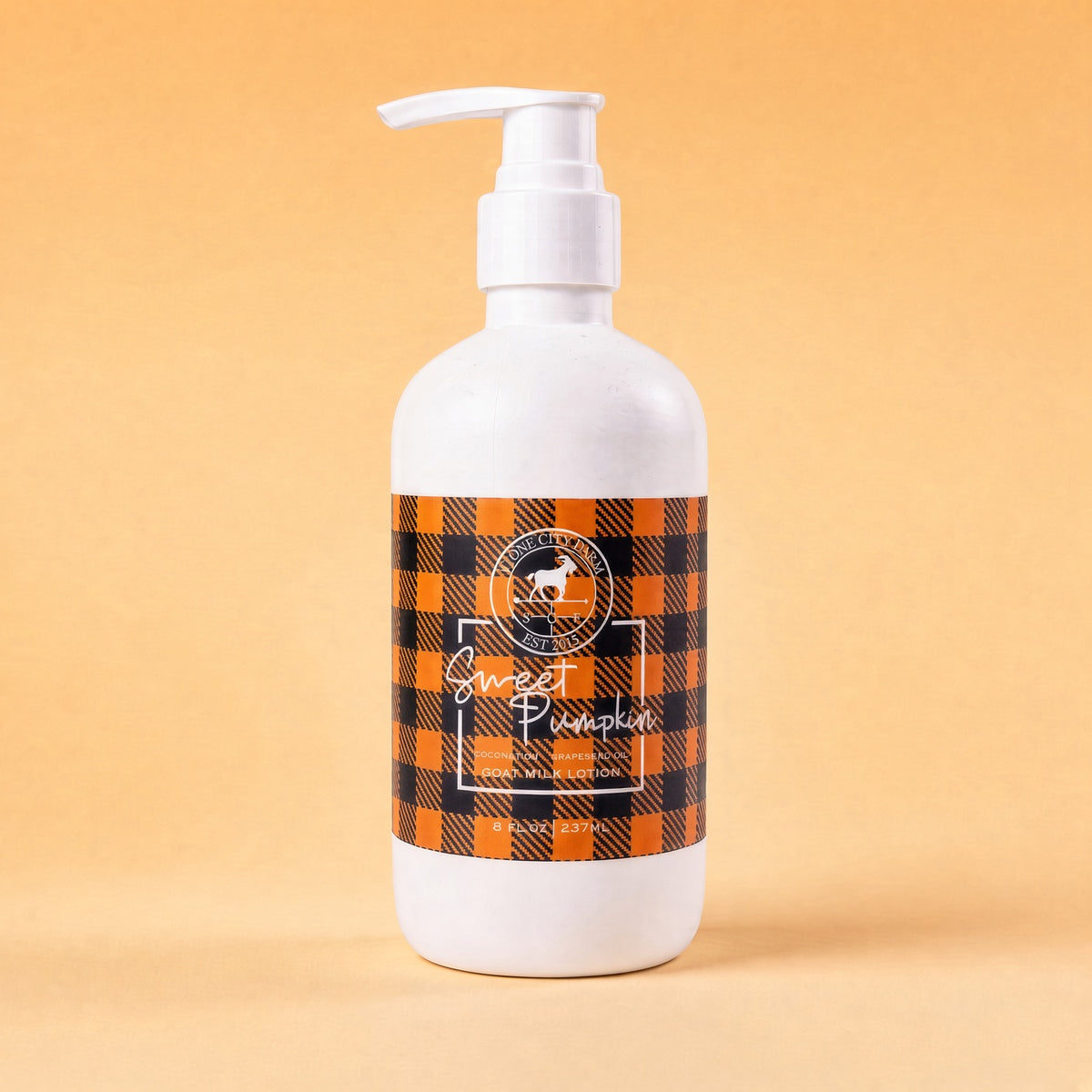 Sweet Pumpkin goat milk lotion on an orange backdrop